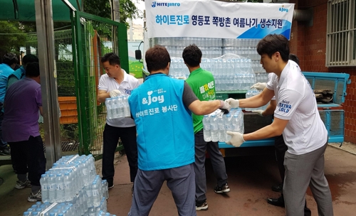 ▲하이트진로 임직원들은 20일 서울 영등포 쪽방촌 거주민 700세대에 생수 1만4000여 병을 전달했다. ⓒ하이트진로