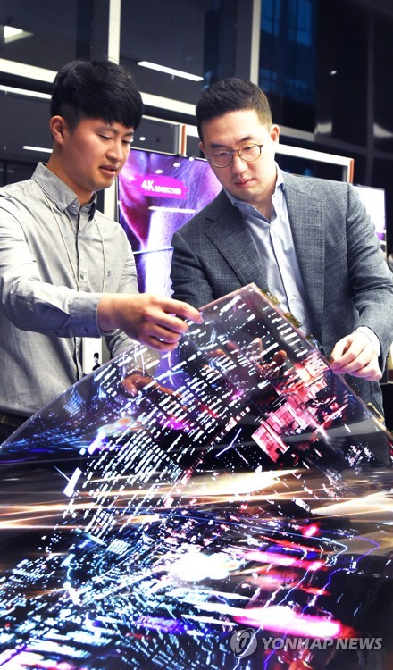 ▲구광모 LG 대표(오른쪽)가 연구원과 함께 '투명 플렉시블 OLED'를 살펴보고 있다. ⓒLG그룹