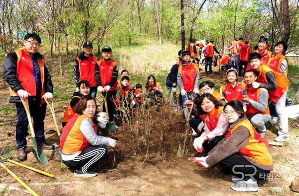 ▲SK건설 임직원 가족봉사단이 지난 13일 화단에 나무를 심고 기념촬영을 하고 있다. ⓒSK건설