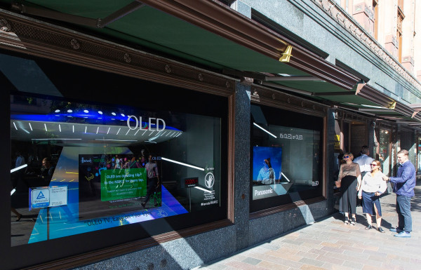 ▲LG디스플레이가 영국 해롯백화점 1층 쇼윈도에 전시한 글로벌업체들의 OLED TV를 방문객들이 관람하고 있다. ⓒLG디스플레이