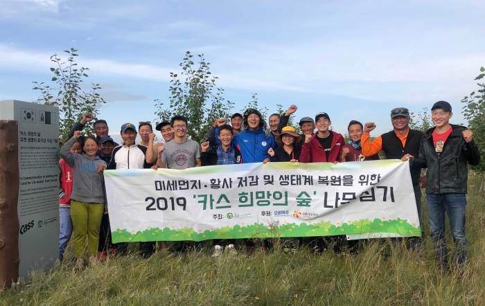 ▲푸른아시아 관계자, 몽골 대학생, 현지 주민으로 구성된 환경봉사단 20여 명이 몽골 ‘카스 희망의 숲’ 일대에서 나무심기 봉사활동을 마치고 기념촬영을 하고 있다.ⓒ오비맥주