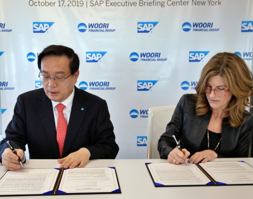 ▲손태승(사진 왼쪽) 우리금융그룹 회장과 제니퍼 모건(Jennifer Morgan) SAP CEO가 협약서에 서명하고 있다. ⓒ우리은행