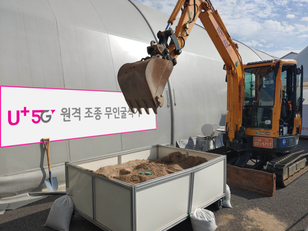 ▲성남 서울공항 전시장 밖에 마련된 작업장에서 5G 무인 굴삭기가 시연을 펼치는 모습. ⓒLG유플러스