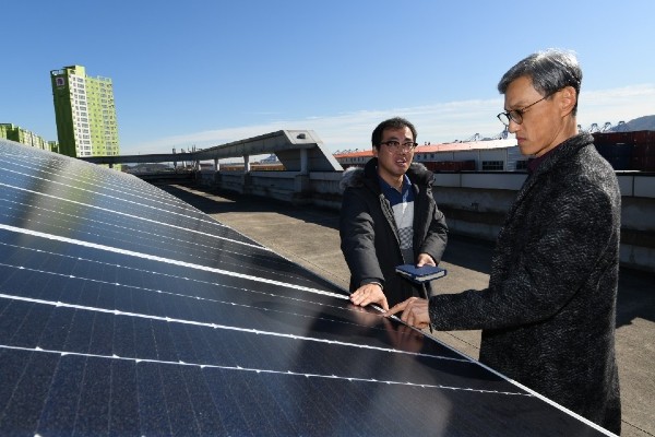 ▲건물 옥상에 설치된 태양광 패널을 살펴보고 있는 SK에너지 조경목 사장(오른쪽) ⓒSK에너지