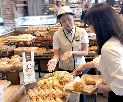 ▲한 고객이 뚜레쥬르 매장에서 기부연계형 나눔 제품인 착한빵을 구매하고 있다. ⓒCJ푸드빌
