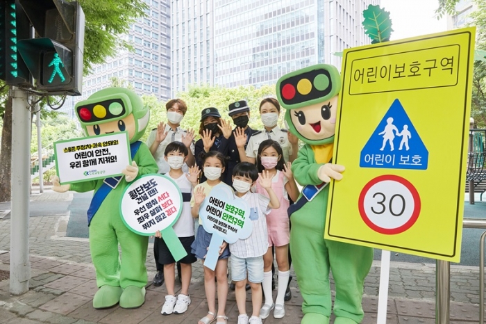 ▲어린이들이 경찰관, 서울녹색어머니연합, 도로교통공단 교통안전교육지도사와 함께 어린이 보호구역 교통안전을 위한 사진을 촬영하고 있다. ⓒ도로교통공단