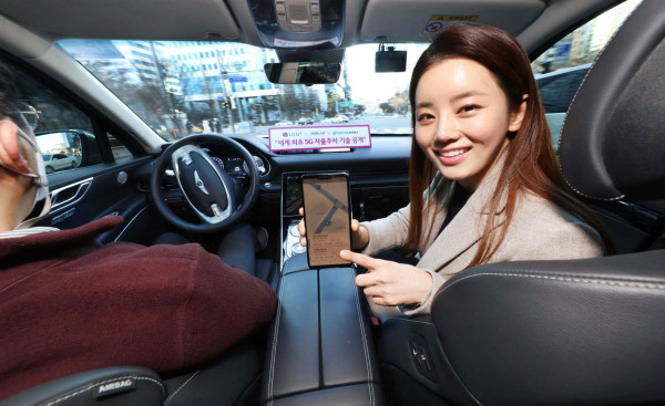▲LG유플러스 모델이 서울시 상암 5G 자율주행 시범지구에서 5G 자율주행차 'A1(에이원)'에 탑승해 모바일 앱으로 차량의 현재 위치를 확인하는 모습. ⓒLG유플러스