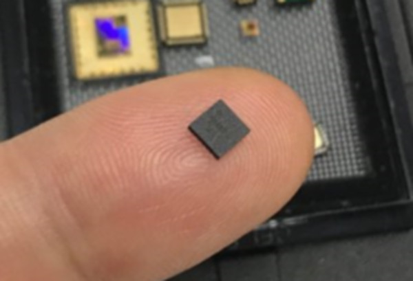 ▲이번에 개발된 IoT 단말용 초소형 양자보안칩을 검지 손가락에 올려놓은 모습. ⓒLG유플러스