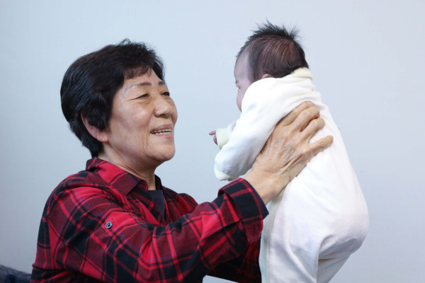 ▲LG의인상을 수상한 전옥례씨(74세, 사진 왼쪽)가 서울 서대문구에 위치한 자택에서 위탁아동을 돌보는 모습. ⓒLG