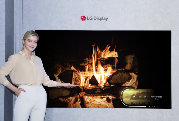 ▲LG디스플레이 모델이 신규 OLED 소자가 적용된 77인치 차세대 OLED TV 패널을 소개하고 있다. ⓒLG디스플레이
