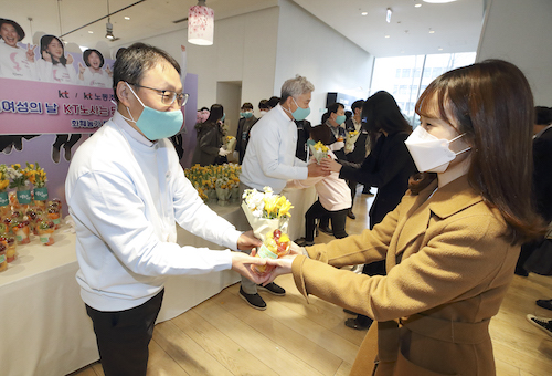 ▲구현모 KT 대표와 최장복 노조위원장이 광화문에 위치한 KT 이스트 사옥에서 여성 임직원에게 꽃을 나눠주고 있다. ⓒKT