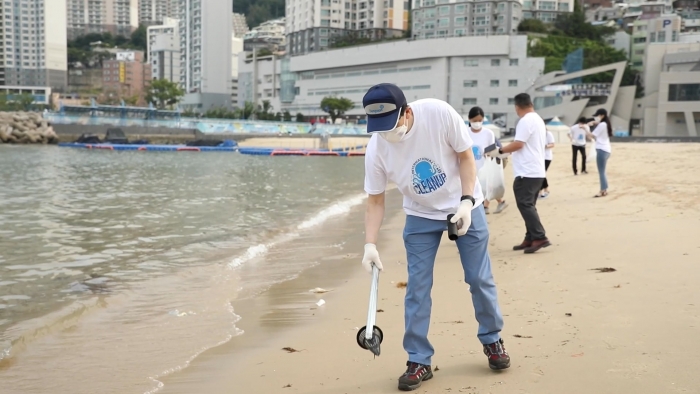 ▲‘국제 해안 클린업 데이’ 행사에 참가한 동원산업 직원이 부산 송도해수욕장에서 쓰레기를 수거하고 있다ⓒ동원산업