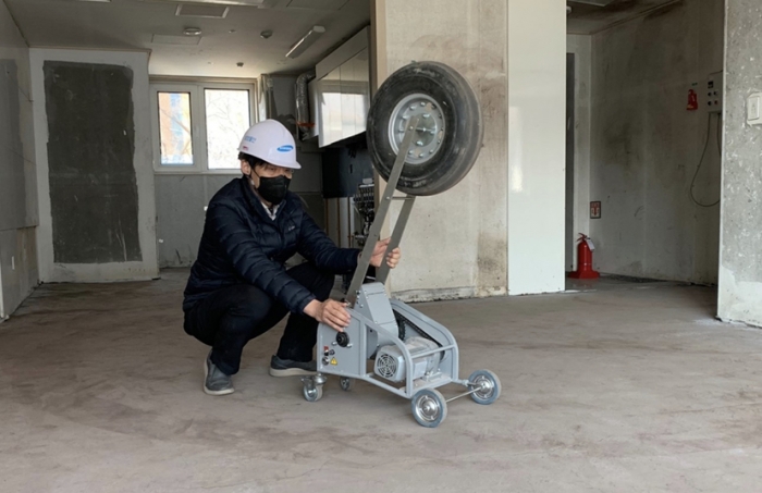 ▲삼성물산 직원이 '뱅 머신'(Bang Machine)을 이용해 중량충격음 실험을 하고 있다. ⓒ삼성물산