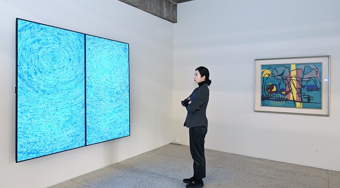▲모델이 서울 용산구 보광동에 위치한 가나아트 보광에서 김환기 화백의 대표작 '우주'의 대체불가토큰(NFT) 작품을 감상하고 있다. ⓒLG전자