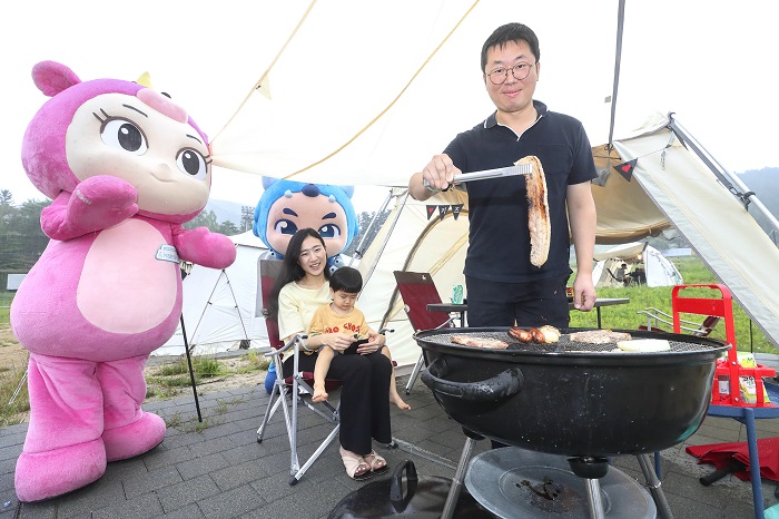 ▲KT 고객이 키즈랜드 꼬마요정 유니, 파비와 함께 캠핑장에서 바베큐를 즐기고 있다. ⓒKT