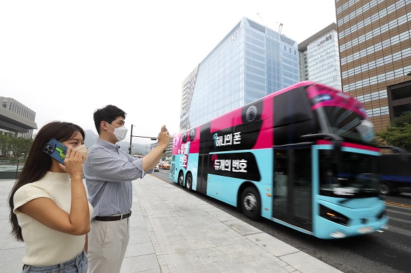 ▲KT 고객이 ‘듀얼번호 버스’를 촬영해 SNS 올리는 인증샷 이벤트에 참여하고 있다. ⓒKT