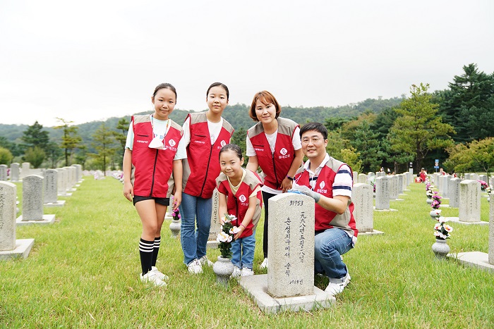 ▲롯데건설 임직원과 가족들이 자매결연 묘역에서 봉사활동 후 기념 촬영을 하고 있다. ⓒ롯데건설