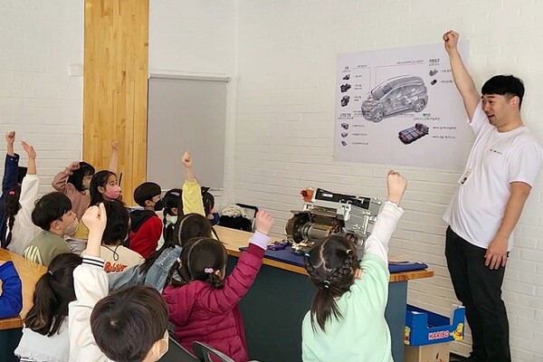 ▲LG마그나 이파워트레인 직원이 청람초등학교 학생들에게 자사가 생산한 부품을 교구로 활용해 전기차에 대해 설명하는 모습. ⓒLG마그나 이파워트레인