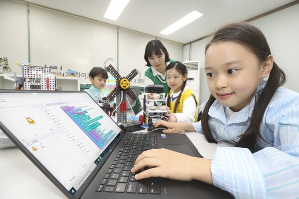 ▲선생님이 초등학생들에게 KT AI 코디니를 이용해 코딩·하드웨어 융합 교육을 진행하는 모습. ⓒKT