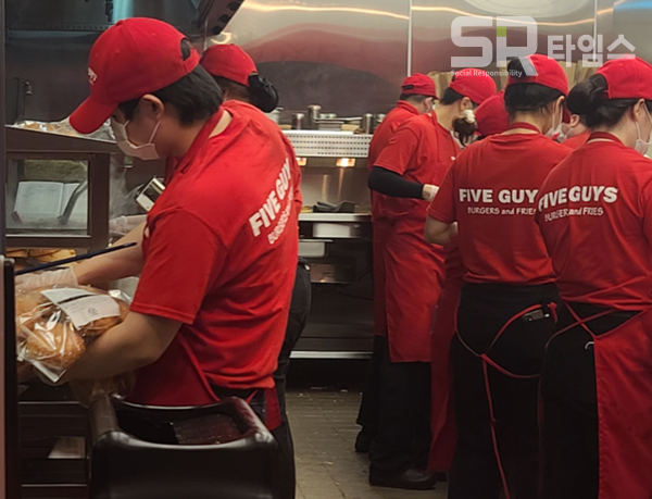 ▲햄버거를 제조하는 파이브가이즈 매장 직원들. ⓒ박현주 기자