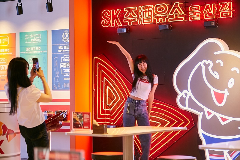 ▲고객이 SK주(酒)유소 팝업스토어 울산점의 ‘네온사인 행코 포토존’에서 기념 촬영을 하고 있다. ⓒSK이노베이션