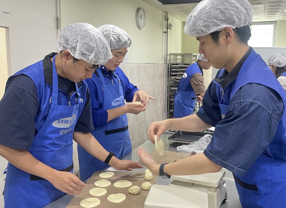 ▲삼성전기 입사 1주년을 맞은 신입사원들이 봉사활동을 하고 있다. ⓒ삼성전기