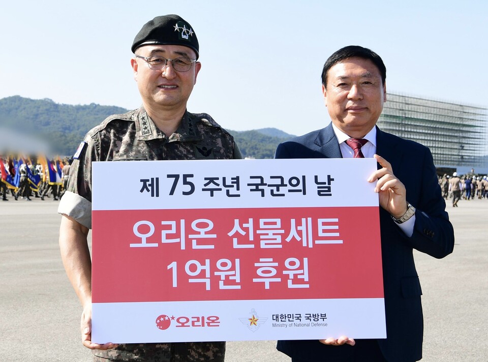 ▲오리온이 제75주년 국군의 날을 맞아 성남 서울공항에서 1억원 상당 선물세트 1만상자를 후원했다. 후원 물품 전달식에 참석한 (왼쪽부터) 박안수 국군의 날 행사 기획단장과 이승준 오리온 대표이사. ⓒ오리온