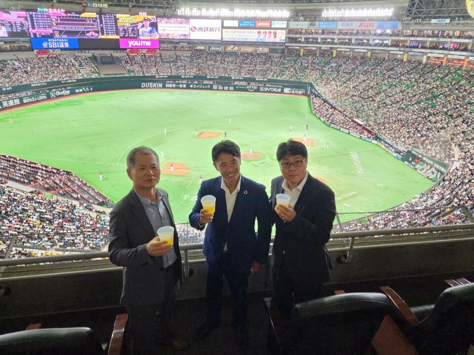 ▲후쿠오카 페이페이돔을 찾은 SK텔레콤과 소프트뱅크, 행복커넥트 관계자들이 다회용컵을 들고 포즈를 취하고 있다. (왼쪽부터) 박대호 사회적기업 행복커넥트 상임이사, 이케다 마사토 소프트뱅크 주식회사 CSR본부장, 이준호 SK텔레콤 ESG추진담당. ⓒ소프트뱅크 주식회사