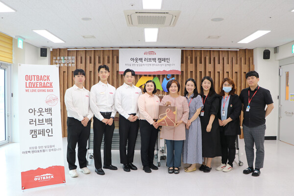 ▲아웃백 펜타포트점 기남영 점주(사진 왼쪽부터 4번째) 및 임직원들이 천안시 종합사회복지관 관계자들과 기념사진을 촬영하고 있다.ⓒbhc그룹