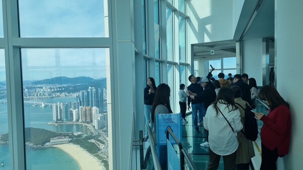 ▲22일 부산엑스더스카이를 방문한 몽골 현지 관계자들이 부산에서 가장 높은 곳에 위치한 전망대에서 부산의 명소를 조망할 수 있는 '파노라믹 오션뷰'를 감상하고 있다.ⓒ풀무원푸드앤컬처