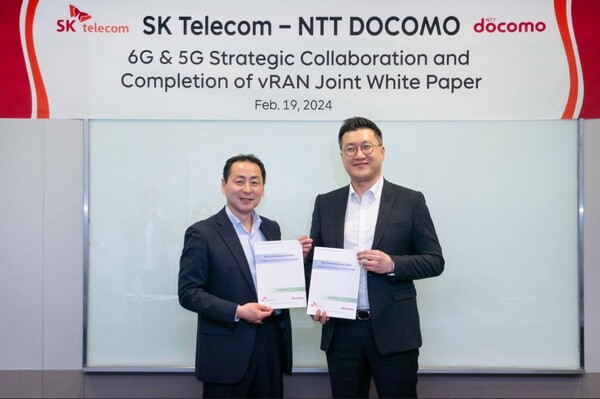 ▲류탁기 SK텔레콤 인프라담당(오른쪽)과 타케히로 나카무라 NTT 도코모 CSO(왼쪽)가 19일 SK텔레콤 본사에서 가상화 기지국 기술 협업 내용을 담은 공동 백서를 완성하고 사진을 찍고 있다. ⓒSK텔레콤