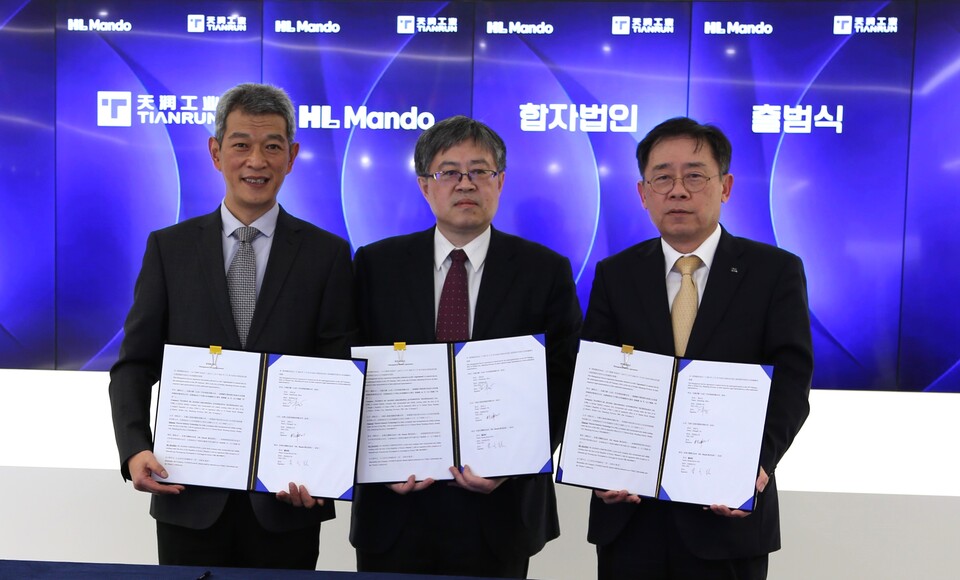 ▲조성현 HL만도 부회장(오른쪽)과 쉬청페이 텐륜공업 CEO(왼쪽), 저우셴중 텐륜만도 CEO가 협약 체결 후 기념 촬영을 하고 있다. ⓒHL그룹