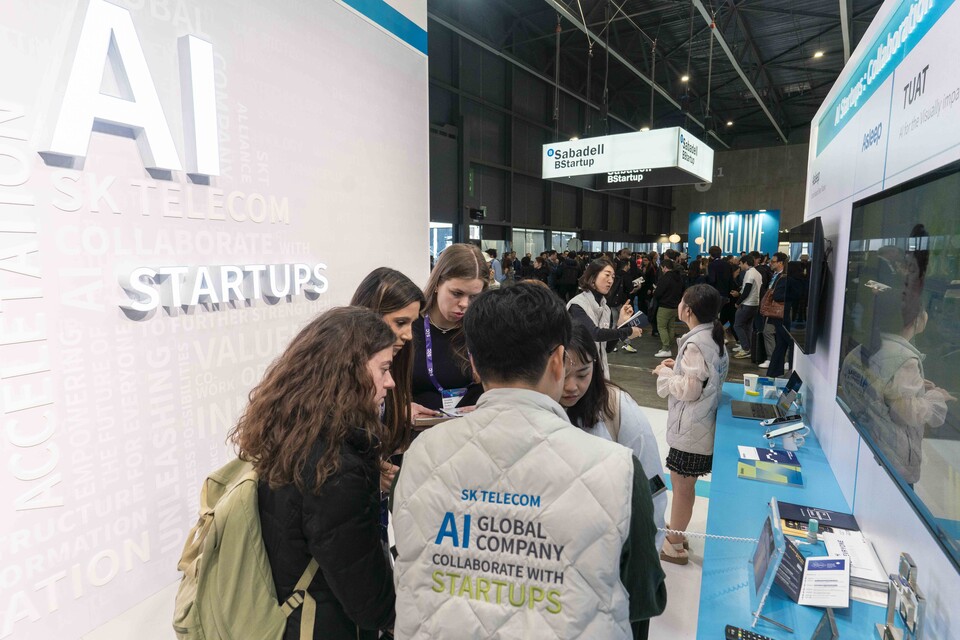 ▲SK텔레콤 관계자가 전시부스를 방문한 관람객들에게 AI 스타트업 서비스와 ICT 기술을 소개하고 있다. ⓒSK텔레콤