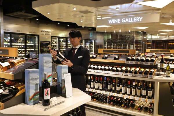 ▲소믈리에가 롯데백화점 잠실점 와인 갤러리에서 관련 와인을 살펴보는 모습. ⓒ롯데쇼핑 