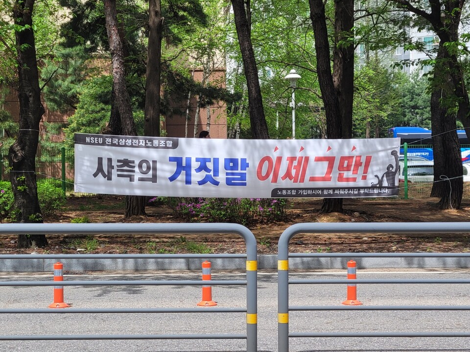 ▲삼성전자 화성사업장 부품연구동 앞 길가에 걸린 현수막. 사측을 비판하는 글귀가 적혀 있다. ⓒ선호균 기자