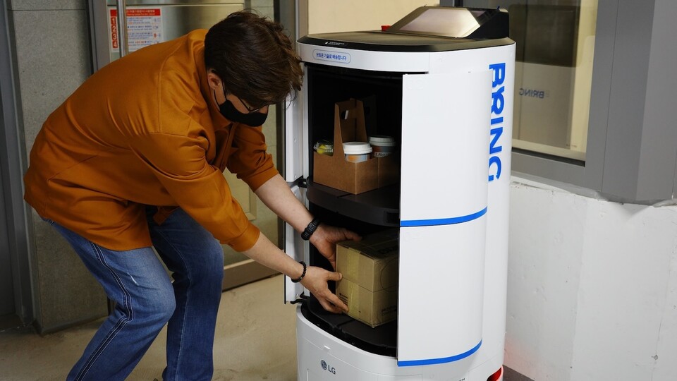 ▲브링 서비스를 이용하기 위해 직원이 배송 로봇에 소포를 싣고 있다. ⓒ카카오모빌리티