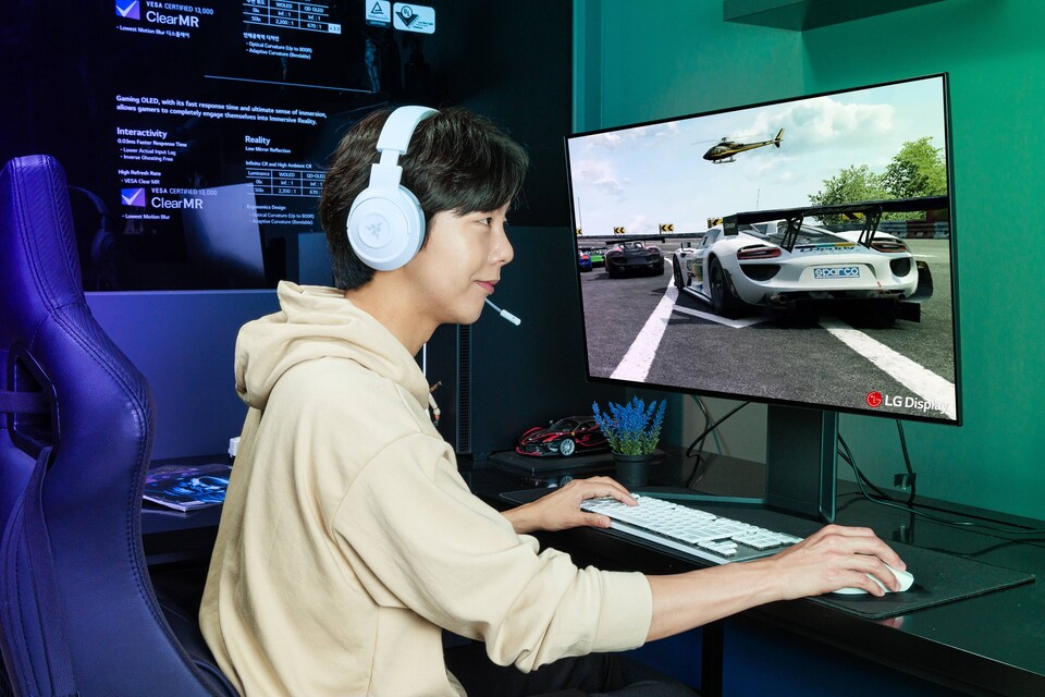 ▲LG디스플레이 모델이 31.5인치 게이밍 OLED 패널로 레이싱 게임을 하고 있다. ⓒLG디스플레이