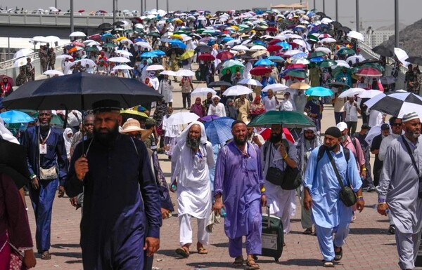 ▲뜨거운 태양을 피하기 위해 양산을 쓰고 순례하는 이슬람교도 ⓒCNN 홈페이지 캡쳐