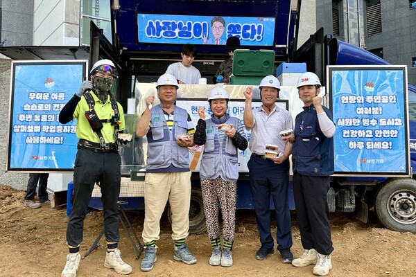 ▲삼환기업의 경기 파주시 운정동 경남아너스빌 건축현장 근로자들이 푸드트럭에서 팥빙수를 받은 뒤 사진 촬영을 하고 있다. ⓒSM그룹