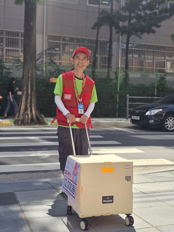 ▲빅이슈 판매원이 동국제강그룹 후원금으로 구매한 카트로 잡지를 운반하고 있다. ⓒ동국홀딩스