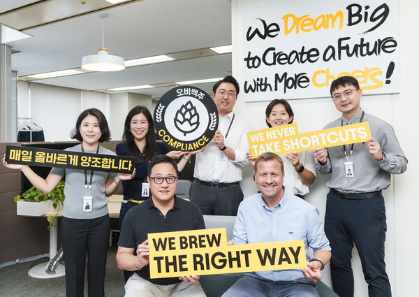▲배하준(앞줄 오른쪽) 오비맥주 대표와 구자범 정책홍보부문 수석부사장(앞줄 왼쪽)이 직원들과 함께 ‘준법의 달’ 행사를 열고 기념 사진을 찍고 있다. ⓒ오비맥주