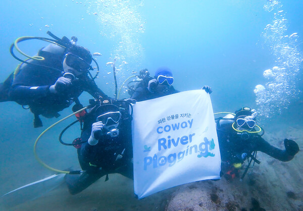 ▲코웨이 임직원 자원봉사단이 강원도 고성 송지호해변 바다에서 수중 쓰레기를 수거하고 있다. ⓒ코웨이