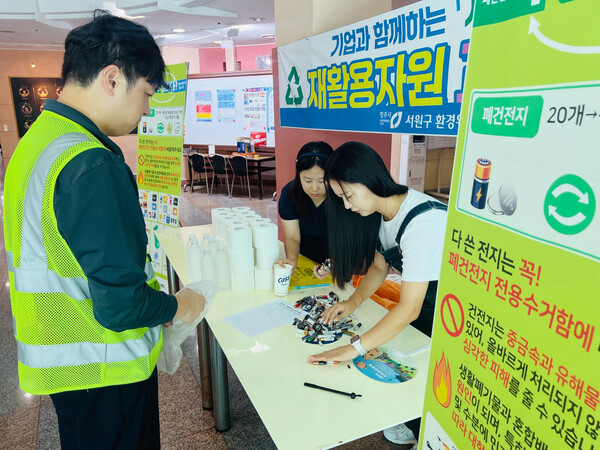 ▲오비맥주 청주공장 임직원이 재활용 자원 교환사업에 참여해 폐건전지를 교환하고 있다. ⓒ오비맥주