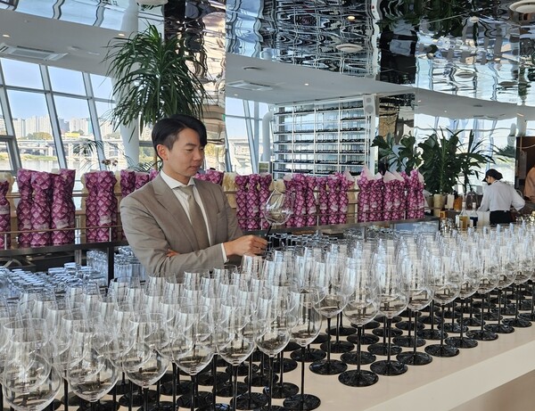 ▲롯데백화점 소믈리에가 와인 블라인드 시음회를 앞두고 심사장을 점검하는 모습. ⓒ롯데쇼핑