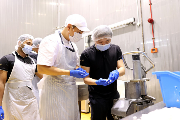 ▲교촌에프앤비 본사 소속 직원(사진 오른쪽 두번째)이 말레이시아 마스터프랜차이즈(MF) 직원들에게 각종 운영 노하우를 전수하고 있다. ⓒ교촌