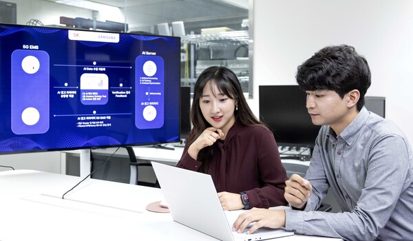 ▲SK텔레콤과 삼성전자 연구원이 AI 기반 5G 기지국 품질 최적화 기술 실증에 대해 논의하는 모습ⓒSK텔레콤
