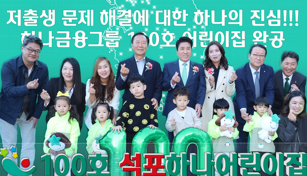 ▲지난달 31일 개원식에 참석한 함영주 하나금융그룹 회장(사진 뒷줄 왼쪽에서 다섯번째)과 박현국 봉화군수(사진 뒷줄 왼쪽에서 네번째)가 어린이집 원장, 학부모, 어린이, 지역주민 등과 함께 1~100호 어린이집이 표시된 한반도 지도가 그려진 배경 앞에서 100번째 어린이집 개원을 축하하며 기념촬영을 하고 있다. ⓒ하나금융그룹