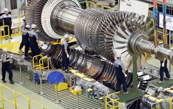 ▲2019년 9월 두산에너빌리티 직원들이 가스터빈 초도호기 최종 조립을 위해 로터 블레이드를 케이싱에 설치하고 있다. ⓒ두산에너빌리티