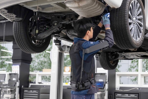 ▲현대차 고양하이테크센터에서 작업자가 ‘엑스블 숄더’를 착용하고 차량 하부를 정비하고 있다. ⓒ현대차·기아