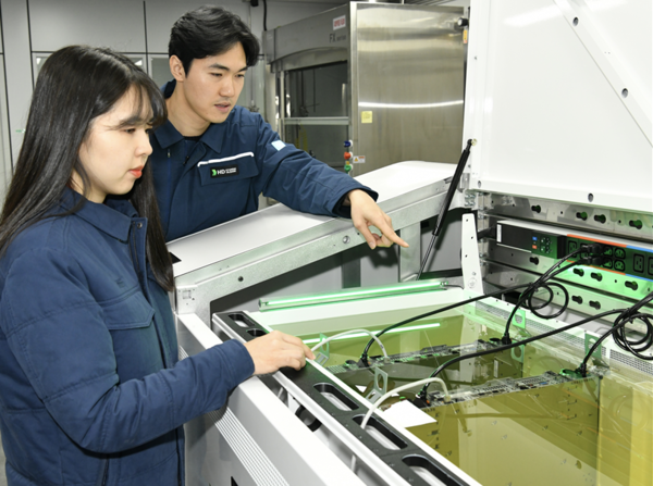 ▲액침냉각설비에 담긴 냉각유와 서버를 테스트하고 있는 HD현대오일뱅크 직원들. ⓒHD현대오일뱅크